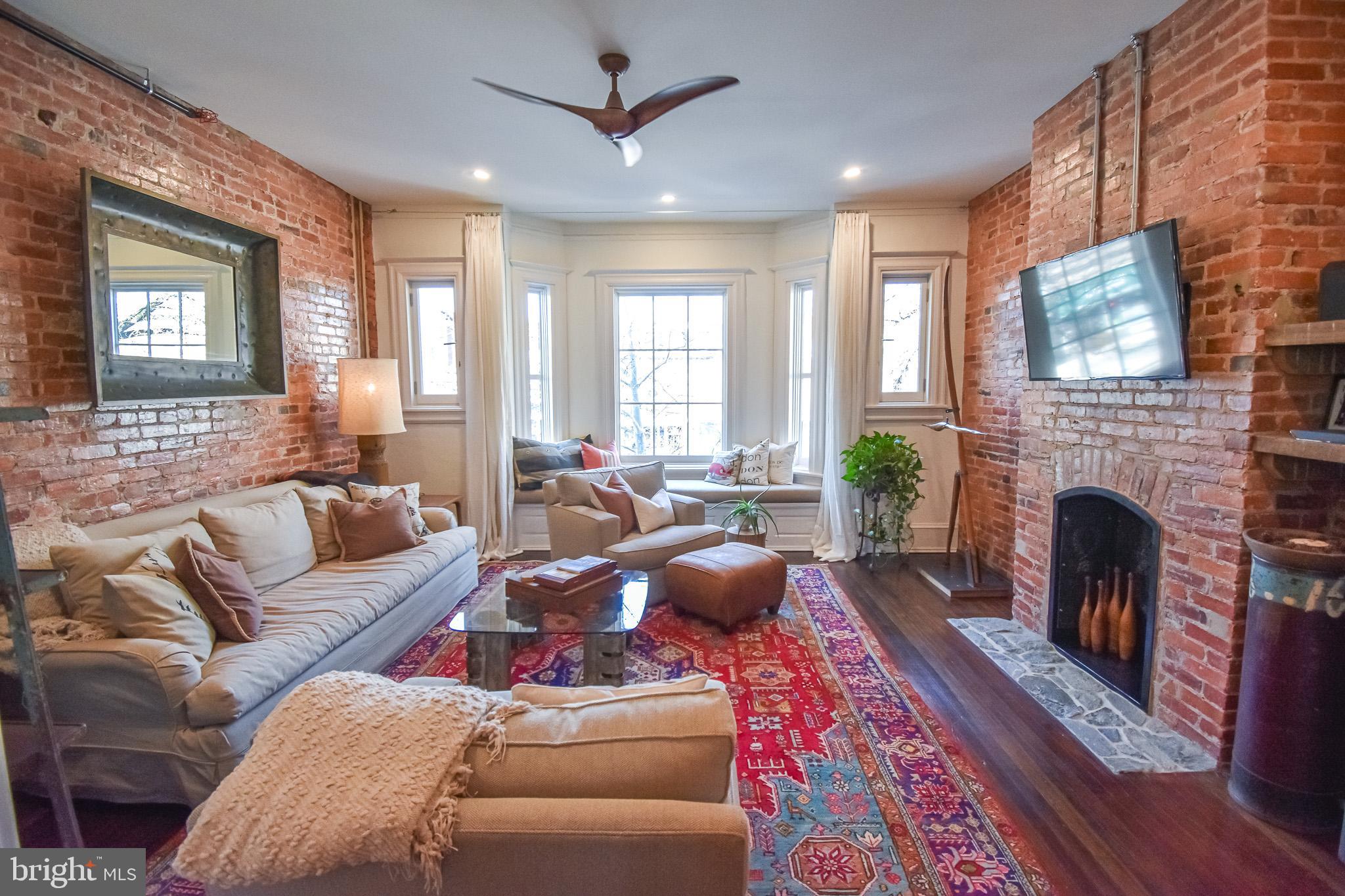 1830 Columbia Road Northwest Washington, DC 20009 - Photo 5 of 46 a living room with furniture a window and a fireplace