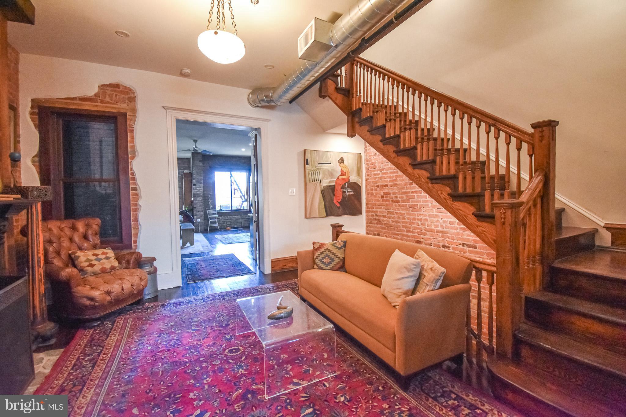 1830 Columbia Road Northwest Washington, DC 20009 - Photo 9 of 46 a living room with furniture and a chandelier