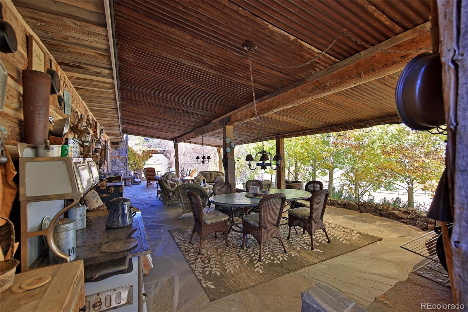 10497-54 54 7/10 Road Molina, CO 81646 - Photo 22 of 45 a view of a patio with table and chairs potted plants with floor to ceiling window