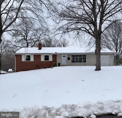 a front view of a house with a yard covered in snow