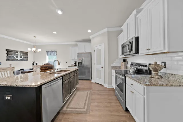 a large kitchen with stainless steel appliances kitchen island granite countertop a large counter top and wooden floors