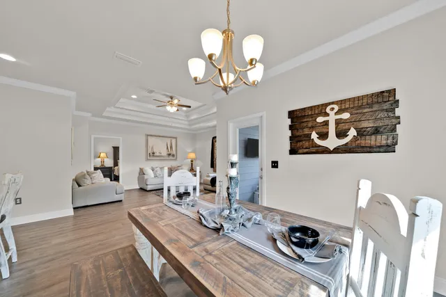 a view of a dining room with furniture a chandelier and wooden floor