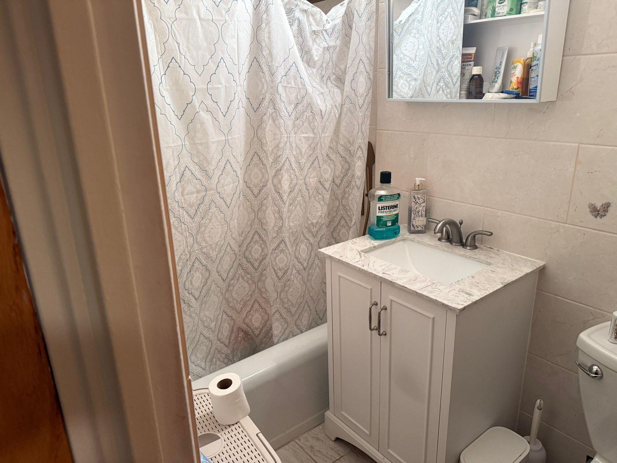 97-37 63rd Road, Unit 5N Queens, NY 11374 - Photo 16 of 17 Bathroom featuring vanity, tile walls, and shower / tub combo