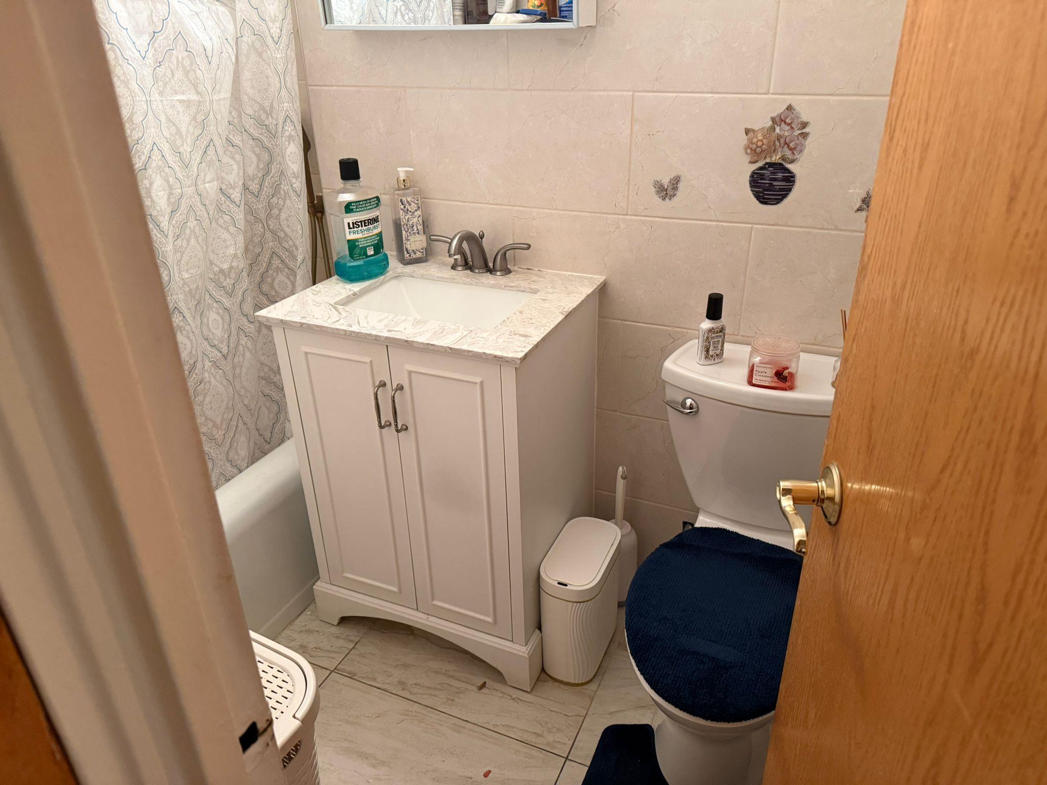 97-37 63rd Road, Unit 5N Queens, NY 11374 - Photo 17 of 17 Bathroom featuring vanity, marble finish flooring, tile walls, and shower / tub combo with curtain
