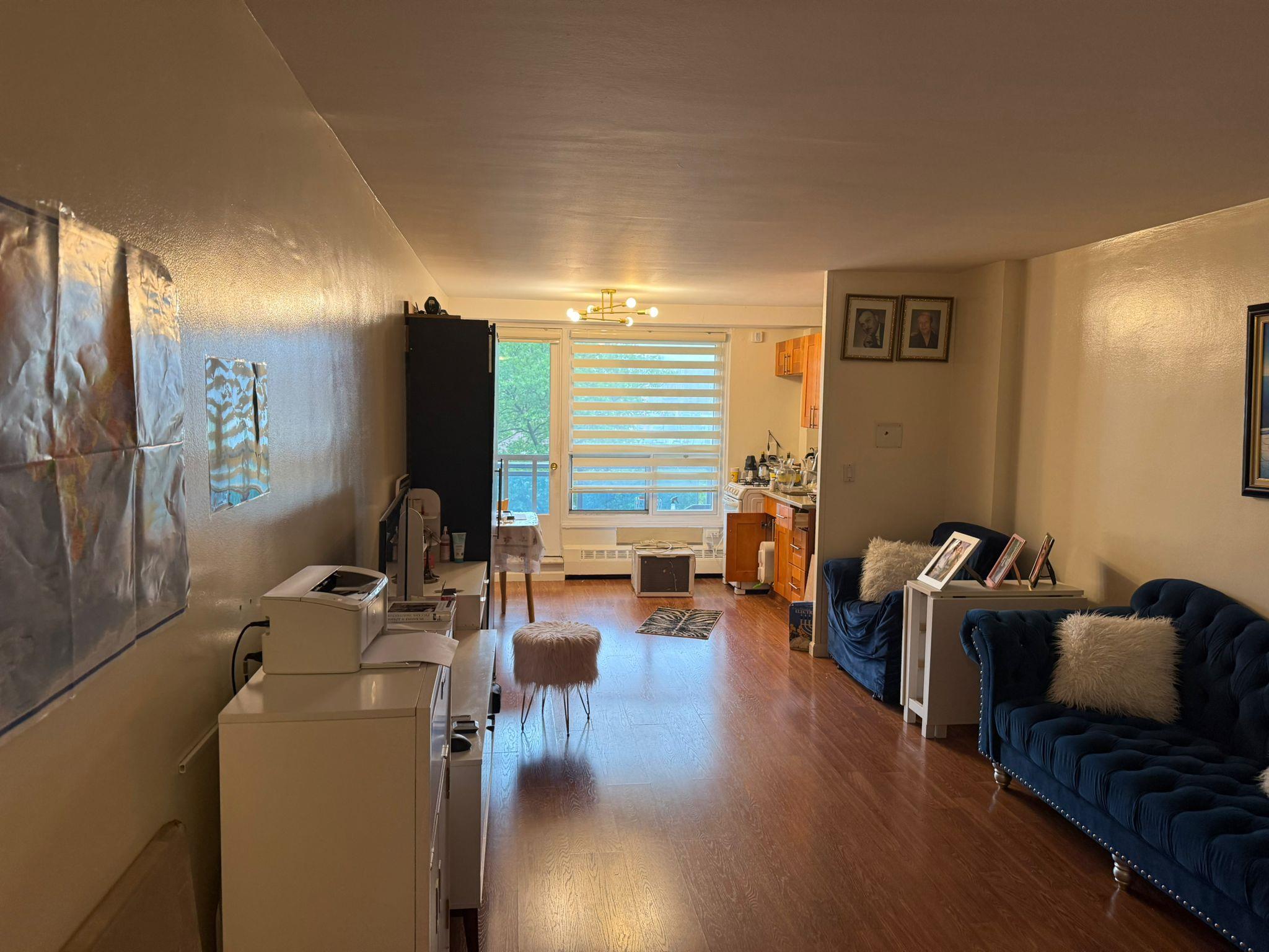 97-37 63rd Road, Unit 5N Queens, NY 11374 - Photo 5 of 17 Living room with wood finished floors, a chandelier, and washing machine and clothes dryer