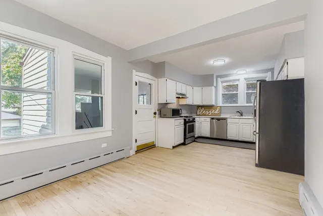a kitchen with a refrigerator and white cabinets