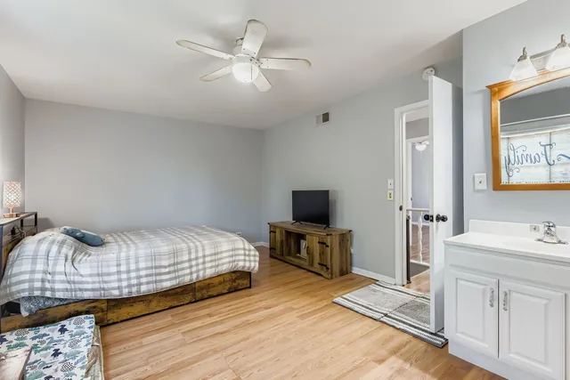 a bedroom with a bed a dresser and flat screen tv