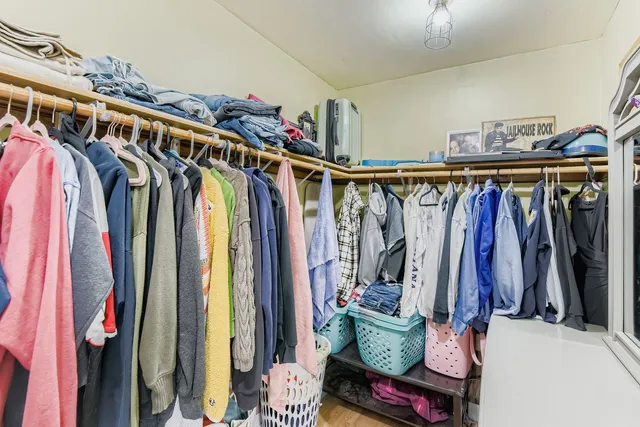 a view of walk in closet with clothes