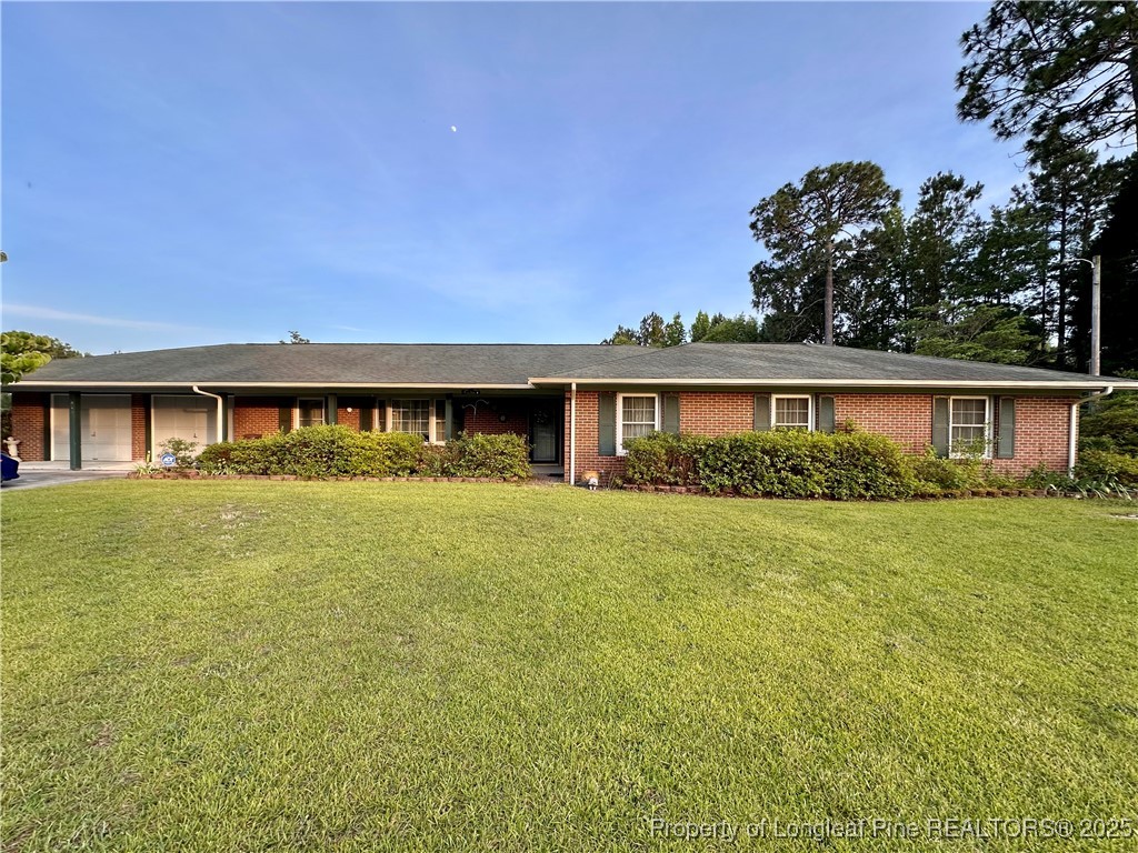 815 Whispering Pines Road Fayetteville, NC 28311 - Photo 1 of 38 a front view of a house with a garden