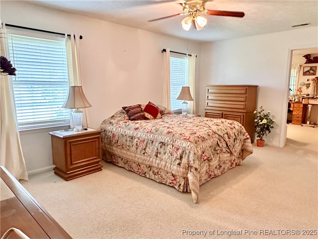 815 Whispering Pines Road Fayetteville, NC 28311 - Photo 11 of 38 a bedroom with a bed and a chandelier