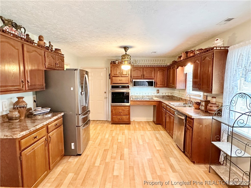815 Whispering Pines Road Fayetteville, NC 28311 - Photo 15 of 38 a kitchen with stainless steel appliances granite countertop a refrigerator a sink dishwasher a stove with wooden cabinets and floor