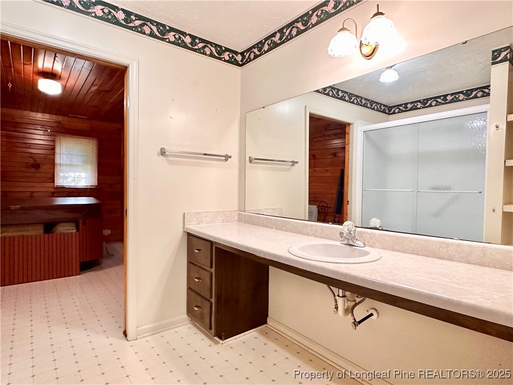 815 Whispering Pines Road Fayetteville, NC 28311 - Photo 27 of 38 a bathroom with a sink a mirror and a bathtub