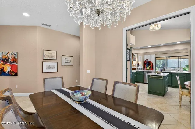 a large dining hall with stainless steel appliances kitchen island granite countertop a sink and cabinets