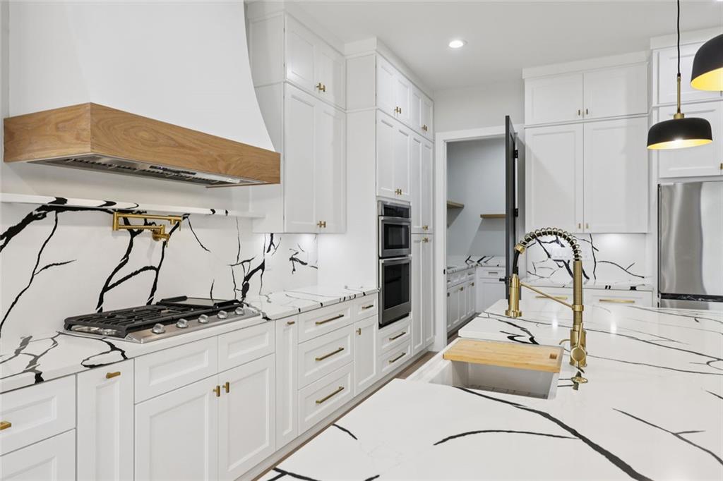 24 Rocking Wood Drive Auburn, GA 30011 - Photo 34 of 101 a kitchen with stainless steel appliances kitchen island granite countertop a stove a sink and a refrigerator