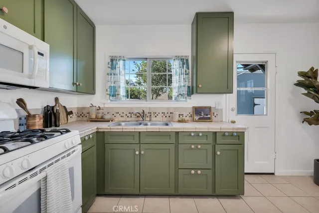 a kitchen with a stove sink and cabinets