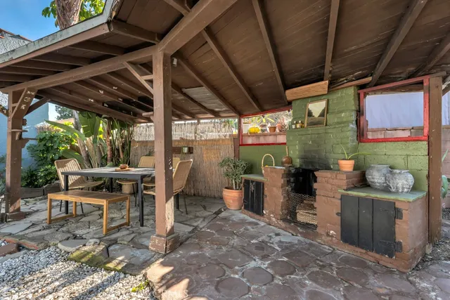 a view of a patio with table and chairs potted plants and floor to ceiling window