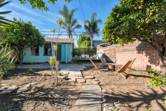 a view of a patio with table and chairs potted plants and large tree
