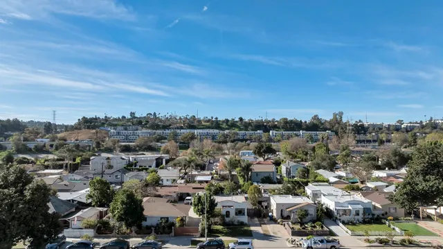 an aerial view of residential houses with outdoor space and trees