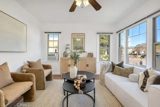 a living room with furniture a chandelier and a wooden floor