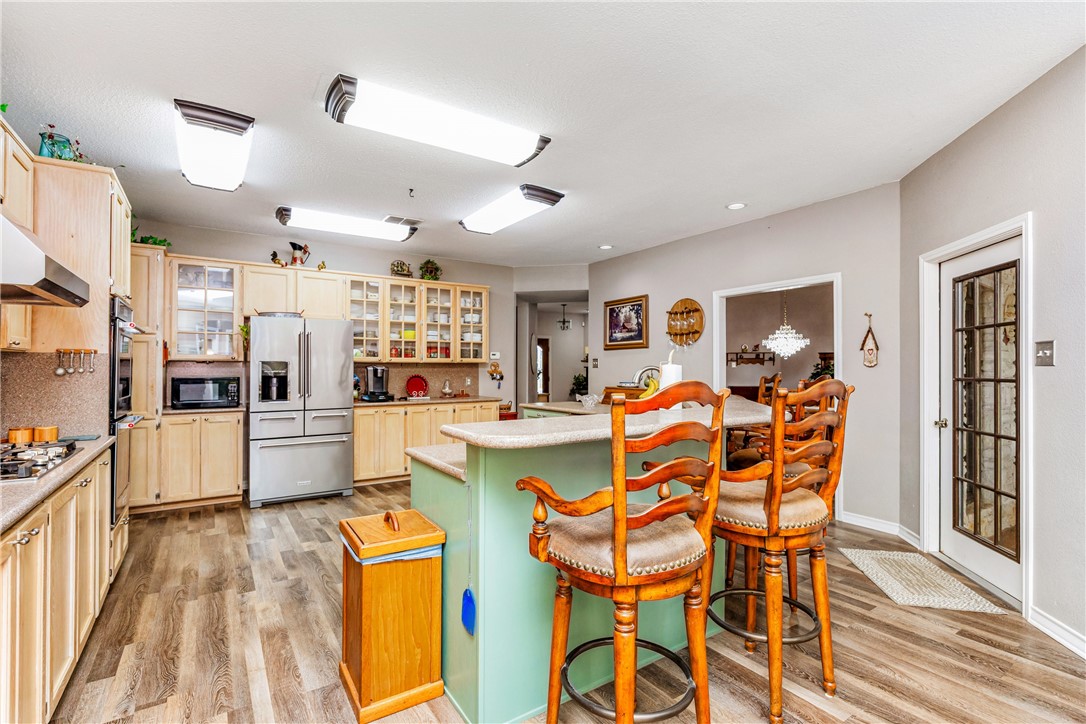 345 Trail Ridge Drive Sandia, TX 78383 - Photo 20 of 40 a dining room with stainless steel appliances kitchen island granite countertop a dining table chairs and chandelier