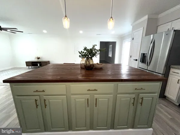 a kitchen with stainless steel appliances granite countertop a stove a refrigerator a microwave a sink a island and chairs with wooden floor