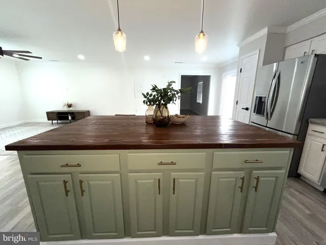 a kitchen with stainless steel appliances granite countertop a stove a refrigerator a microwave a sink a island and chairs with wooden floor