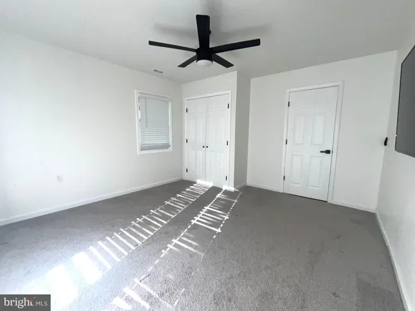 an empty room with a window and a fan