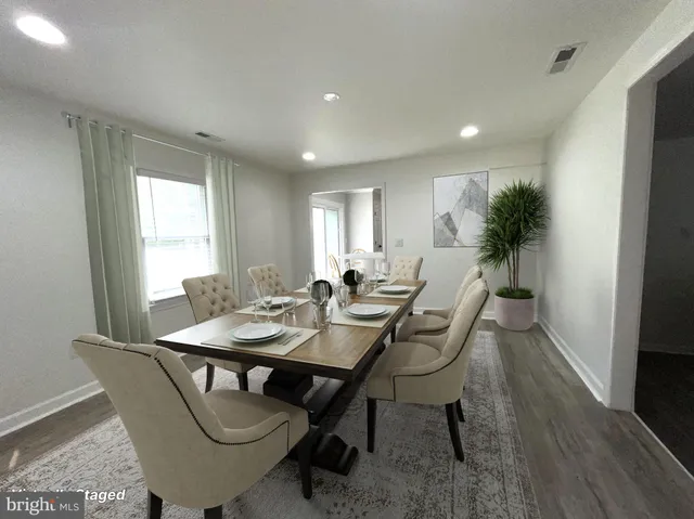 a view of a livingroom with a flat screen tv ceiling fan and wooden floor