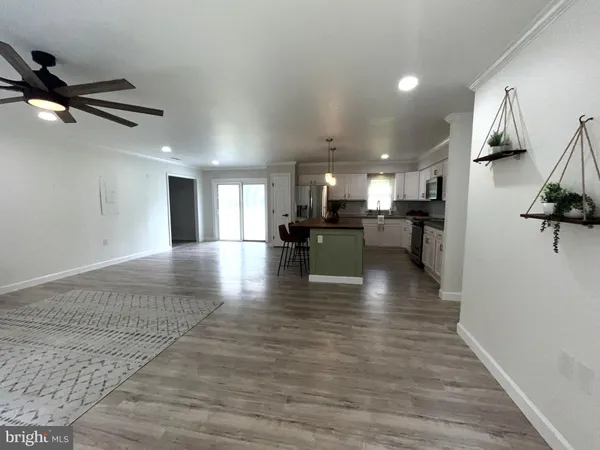 a kitchen with stainless steel appliances granite countertop a sink a stove a refrigerator cabinets and chairs