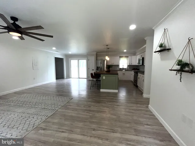 a kitchen with stainless steel appliances granite countertop a sink a stove a refrigerator cabinets and chairs