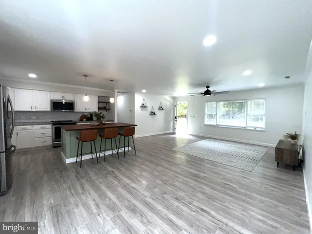 a kitchen with stainless steel appliances granite countertop a sink a stove and a wooden floors
