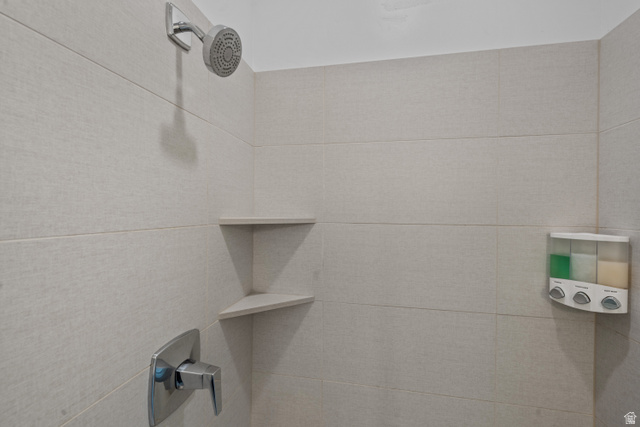 1122 South 1790th West, Unit 1 St. George, UT 84770 - Photo 16 of 37 Shower enclosure featuring large format light-toned wall tiles, a chrome shower head, chrome single-handle valve, and built-in corner shelving