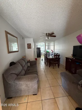 a living room with furniture and a dining table with kitchen appliances