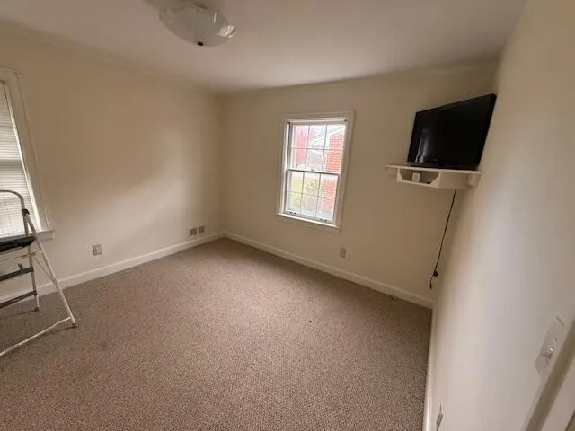 a view of a livingroom with an empty space and a window