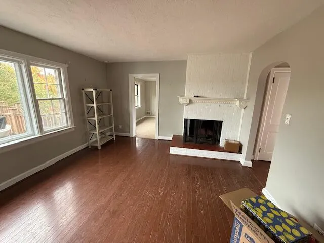 an empty room with windows and fireplace
