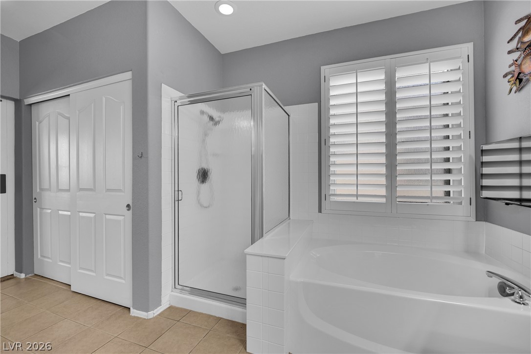 1724 Millstream Way Henderson, NV 89074 - Photo 29 of 60 Indulge in a tranquil retreat featuring a deep soaking tub and a sleek glass-enclosed shower.