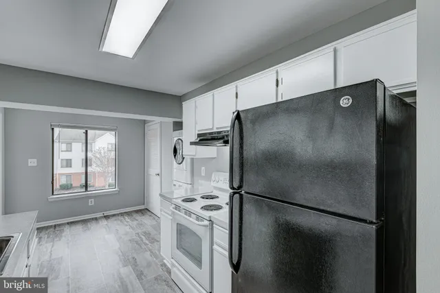 a metallic refrigerator freezer sitting in a kitchen