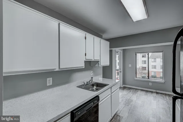 a kitchen with granite countertop a sink stove and cabinets
