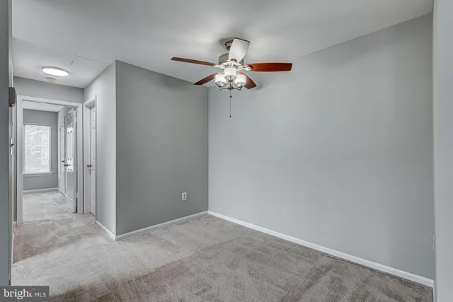 an empty room with closet and a chandelier fan