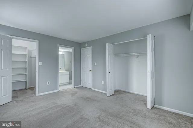 an empty room with closet and wooden door