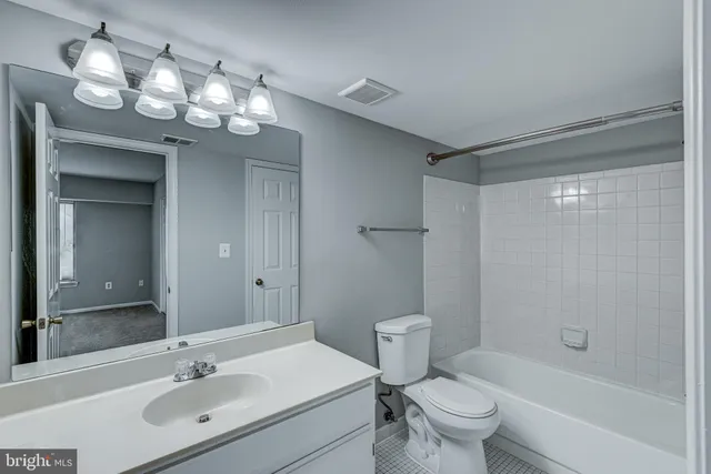 a bathroom with a sink a toilet a mirror and shower