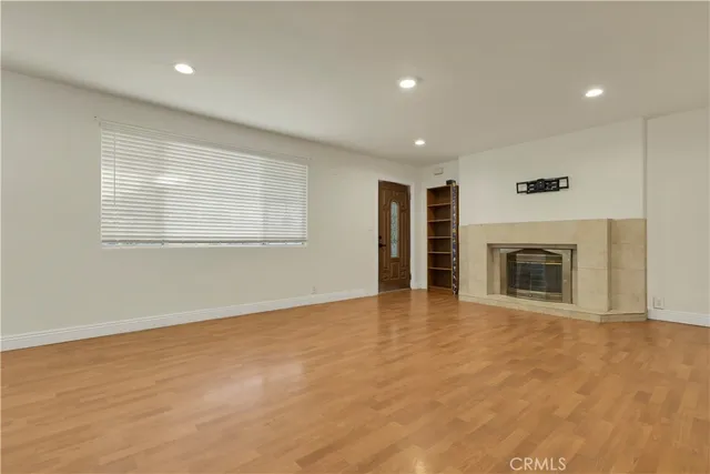 an empty room with windows and fireplace