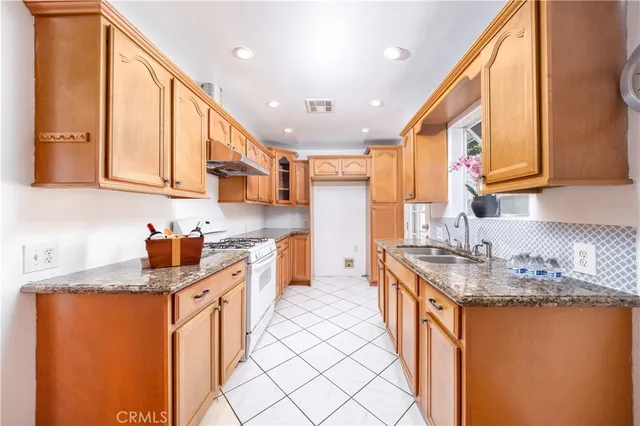 a kitchen with stainless steel appliances granite countertop a sink stove and cabinets