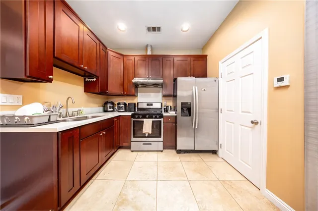 a kitchen with stainless steel appliances granite countertop a refrigerator stove a sink and dishwasher