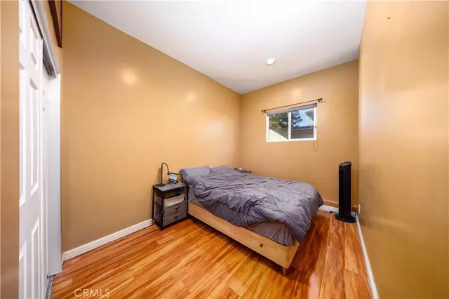 a bedroom with a bed and wooden floor