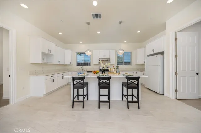 a kitchen with a dining table chairs appliances and cabinets