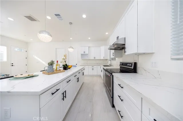 a kitchen with granite countertop white cabinets and white appliances