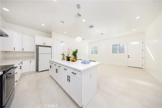 a kitchen with white cabinets and appliances