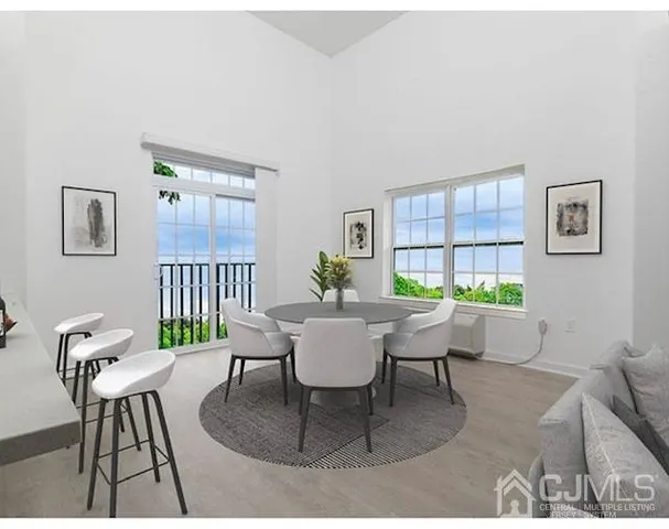 a dining room with furniture a rug and a potted plant