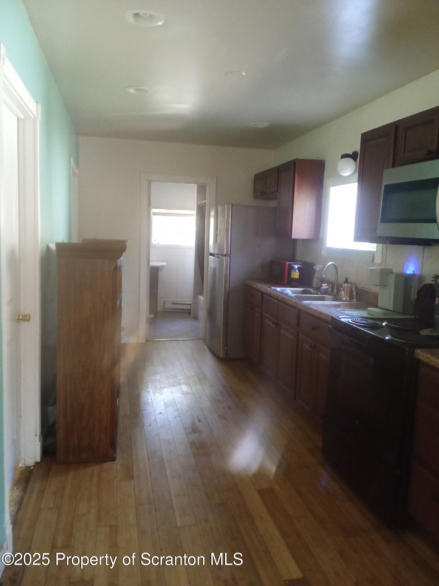 a kitchen with stainless steel appliances granite countertop a refrigerator a sink a stove and microwave